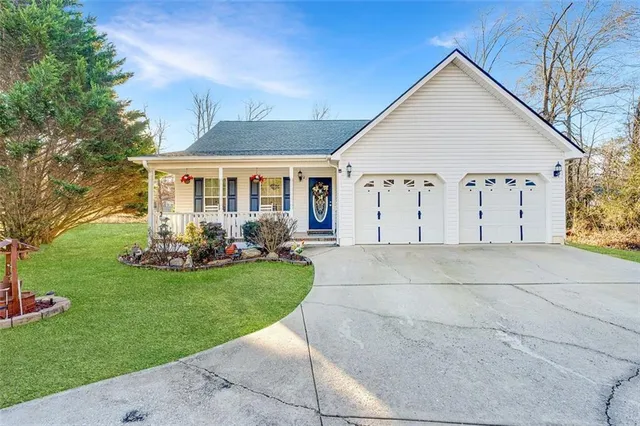 a view of a white house with a big yard and potted plants
