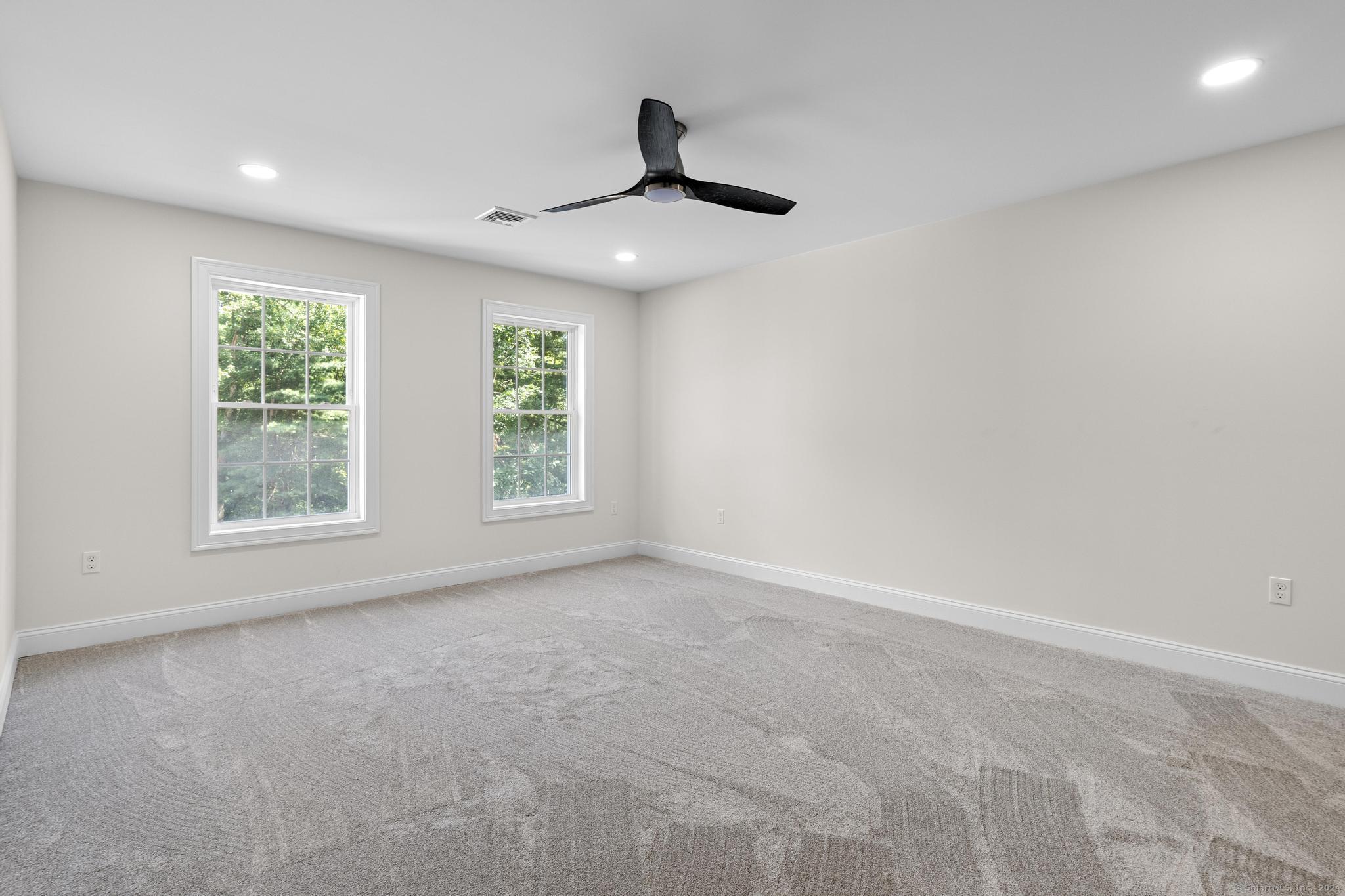 289 Young Street East Hampton, CT 06424 - Photo 8 of 15 an empty room with windows and ceiling fan