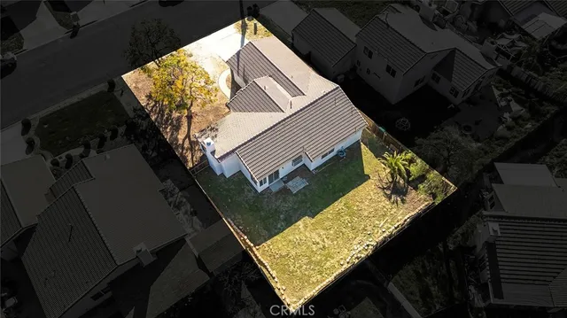 an aerial view of a house with a yard and parking