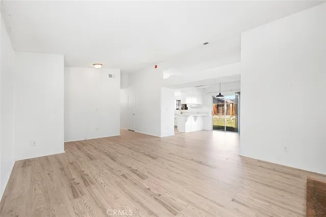 a view of a kitchen with kitchen island a sink wooden floor and a chandelier
