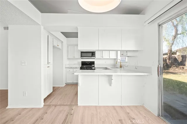 a kitchen with white cabinets and appliances