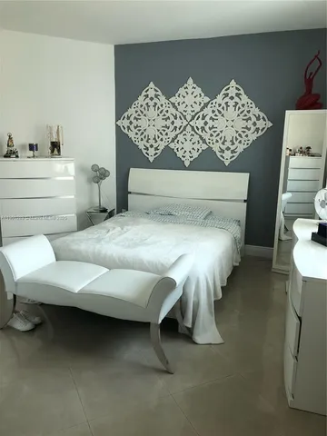 a bed sitting in a bedroom next to a lamp and a table