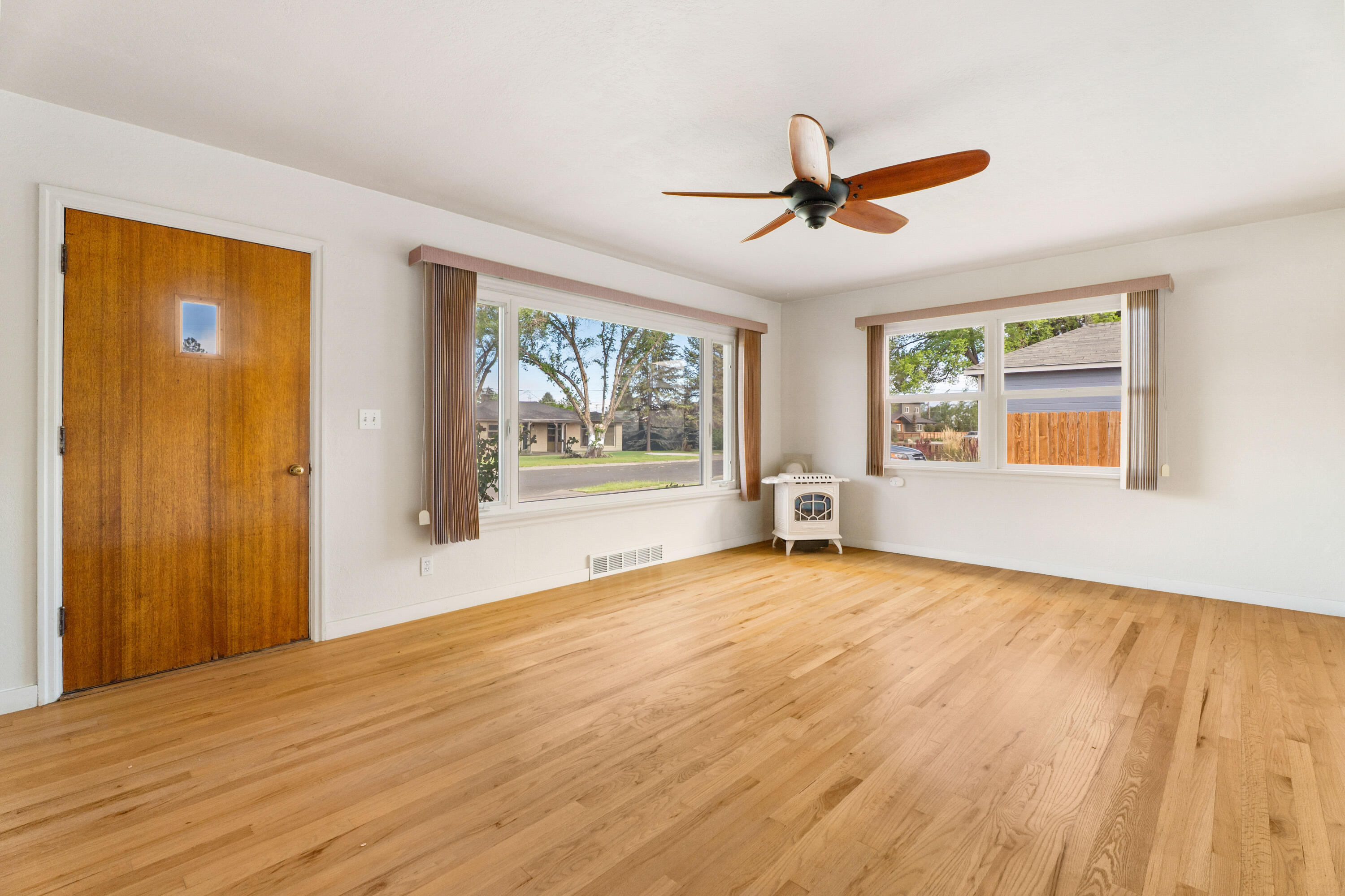 946 Southwest 13th Street Redmond, OR 97756 - Photo 7 of 49 a view of an empty room with a window and wooden floor