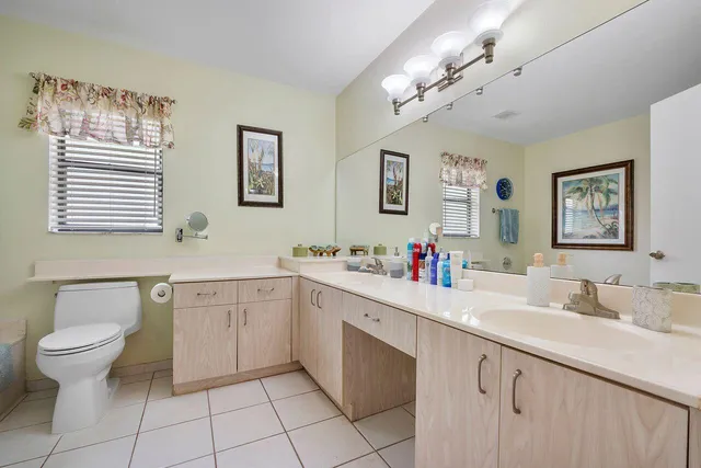 a spacious bathroom with a double vanity sink mirror and toilet