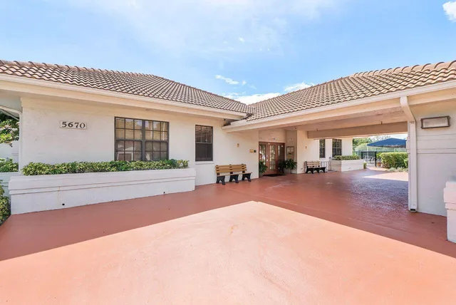 a patio with table and chairs and potted plants