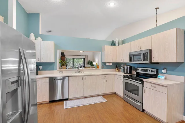 a kitchen with stainless steel appliances granite countertop a stove a sink and a refrigerator