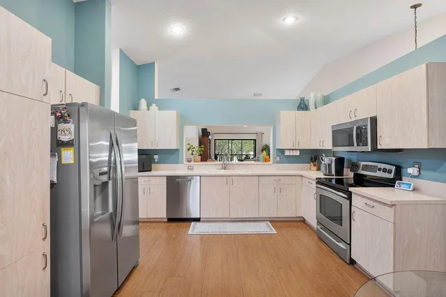a kitchen with white cabinets and stainless steel appliances