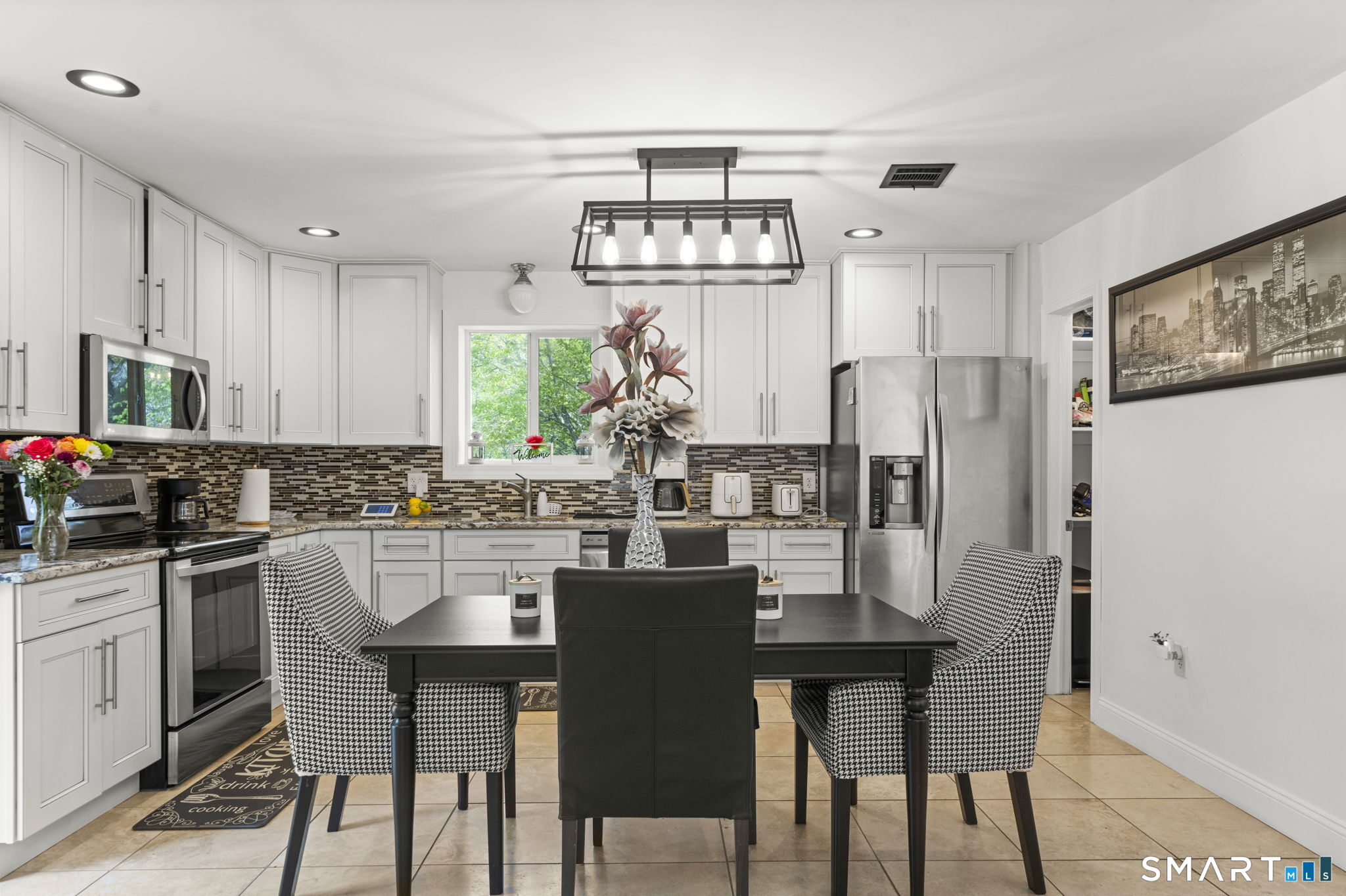 1118 Spindle Hill Road Wolcott, CT 06716 - Photo 10 of 38 a kitchen with stainless steel appliances a dining table chairs and refrigerator
