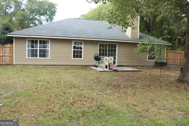 a view of a house with backyard sitting area and garden