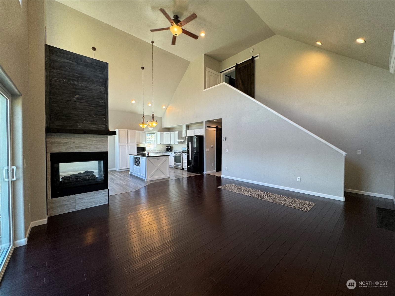 4 Eighme Road Oroville, WA 98844 - Photo 7 of 40 a view of a livingroom with wooden floor a ceiling fan and kitchen view