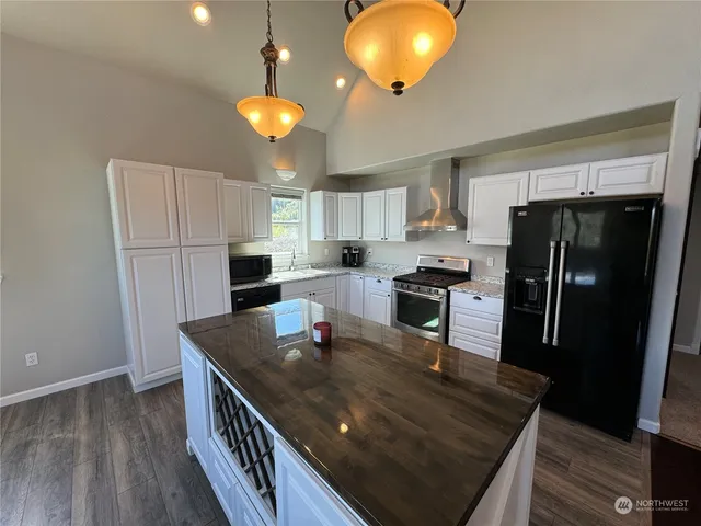 a kitchen with refrigerator cabinets and wooden floor