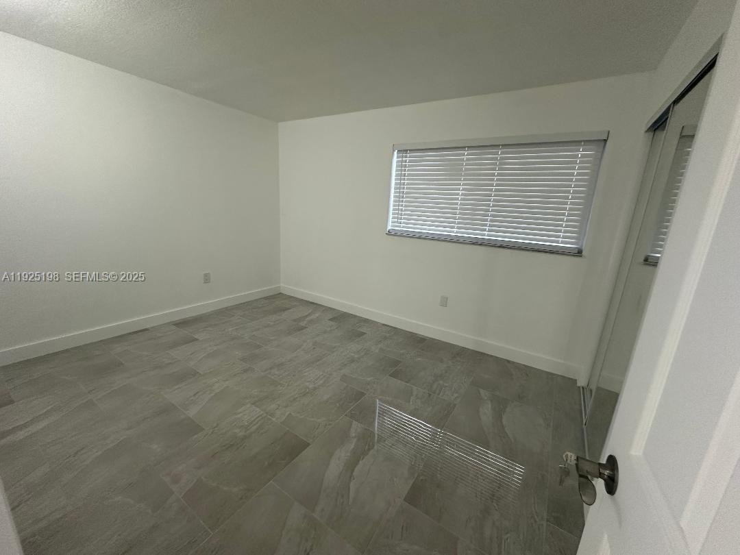 748 82nd Street, Unit 1 Miami Beach, FL 33141 - Photo 5 of 10 an empty room with windows