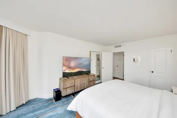 a bedroom with a bed and a flat screen tv
