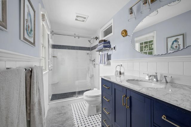 a bathroom with a granite countertop sink toilet and shower