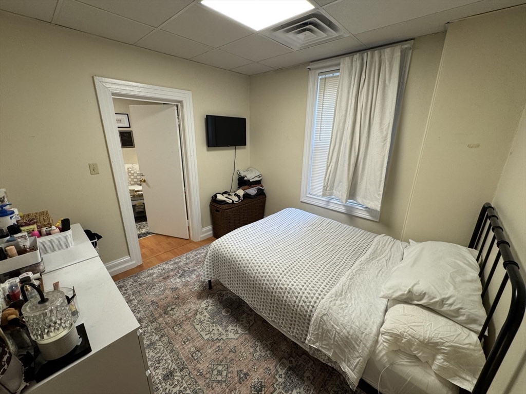 2 Champney Street, Unit 1 Boston, MA 02135 - Photo 3 of 9 a bedroom with a bed and flat tv screen on the dresser