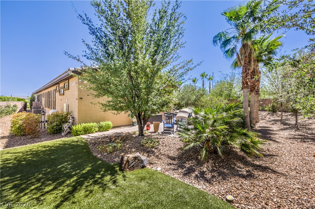 7119 Arabian Ridge Street Las Vegas, NV 89131 - Photo 64 of 73 An inviting backyard oasis offers both artificial turf and natural landscaping for diverse outdoor living.