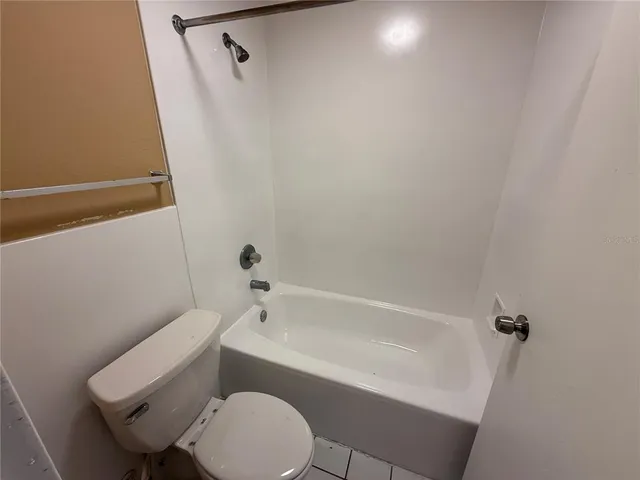 a white toilet sitting next to a bath tub