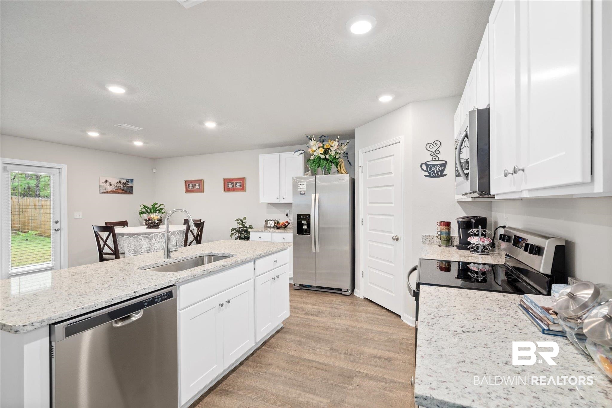 446 Paget Drive East Mobile, AL 36608 - Photo 4 of 20 Kitchen with white cabinets, sink, stainless steel appliances, and an island with sink