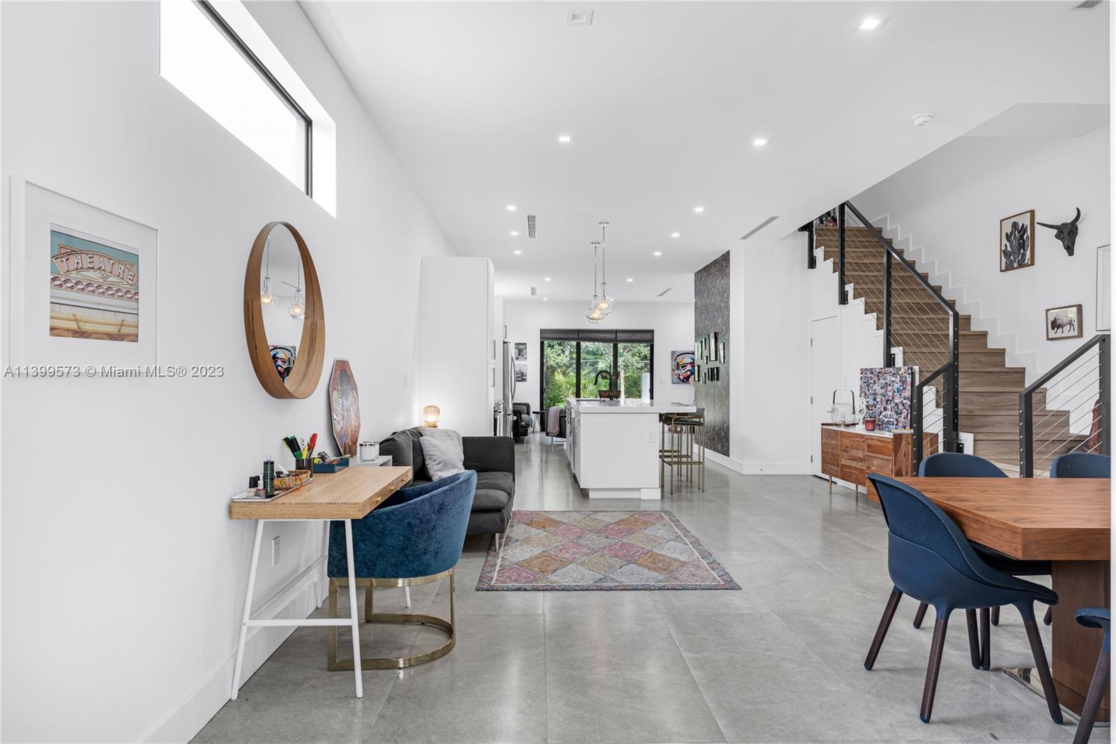 a dining room with furniture a rug and a mirror