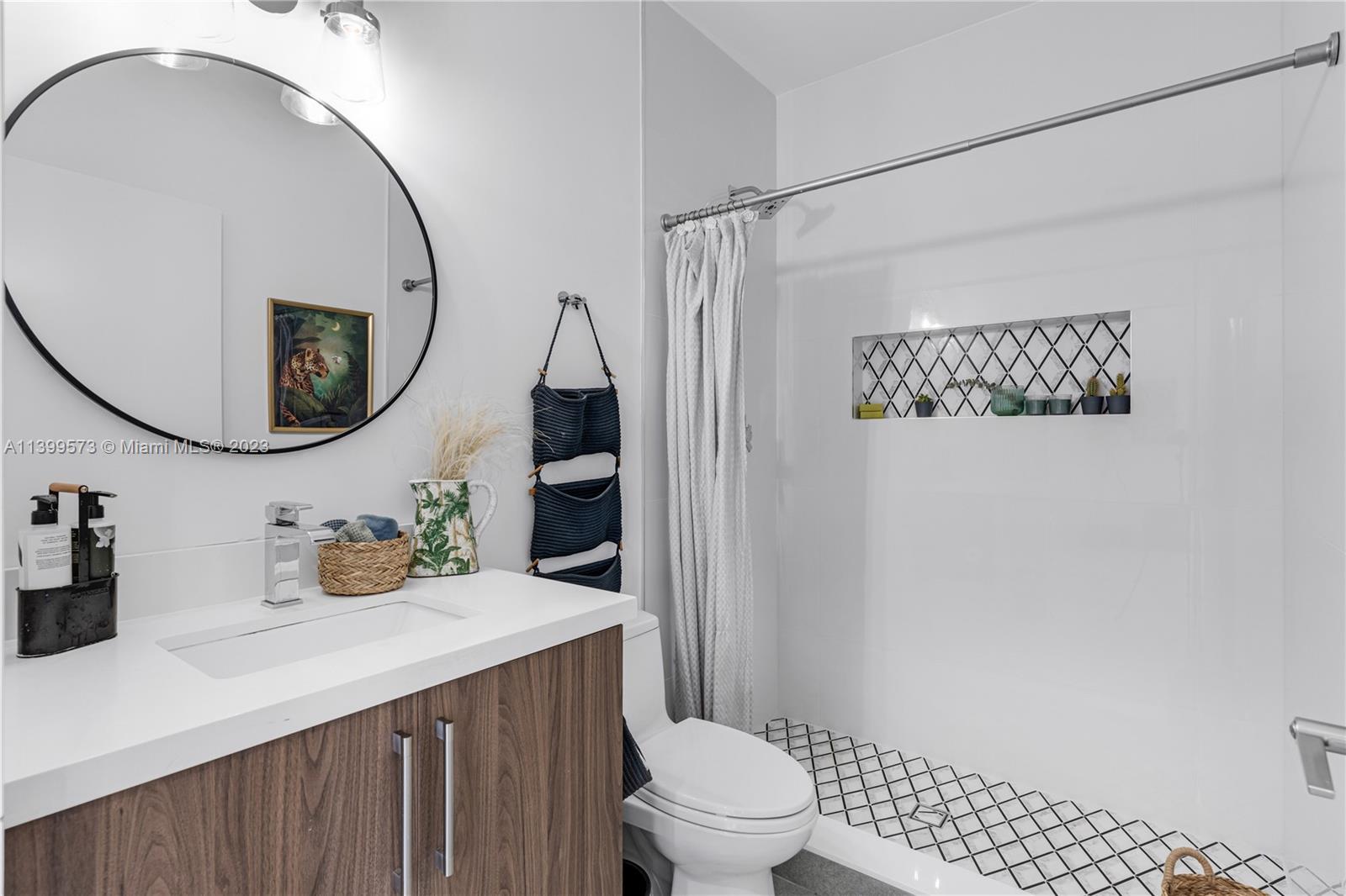 2936 Southwest 35th Avenue, Unit 2936 Miami, FL 33133 - Photo 16 of 22 a bathroom with a sink a toilet and a mirror