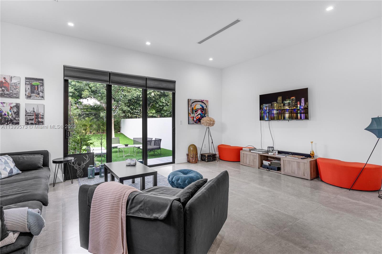 2936 Southwest 35th Avenue, Unit 2936 Miami, FL 33133 - Photo 3 of 22 a living room with furniture a large window and a flat screen tv