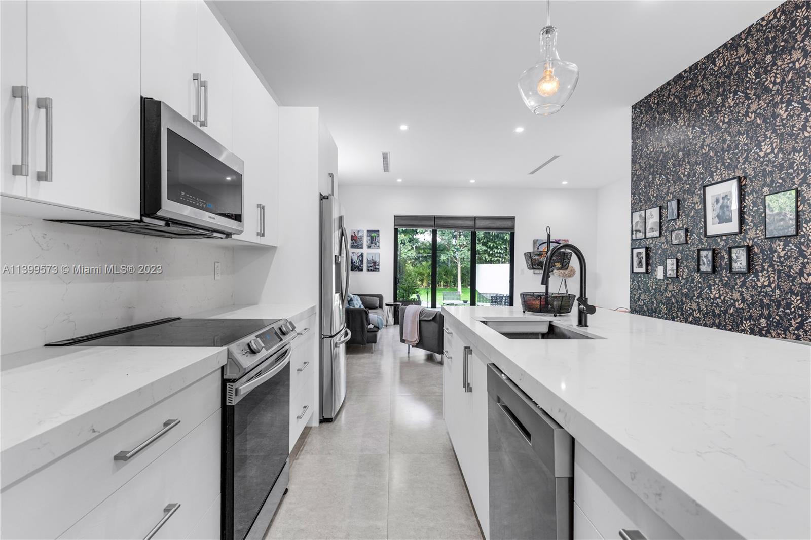 2936 Southwest 35th Avenue, Unit 2936 Miami, FL 33133 - Photo 6 of 22 a kitchen with a stove sink and microwave