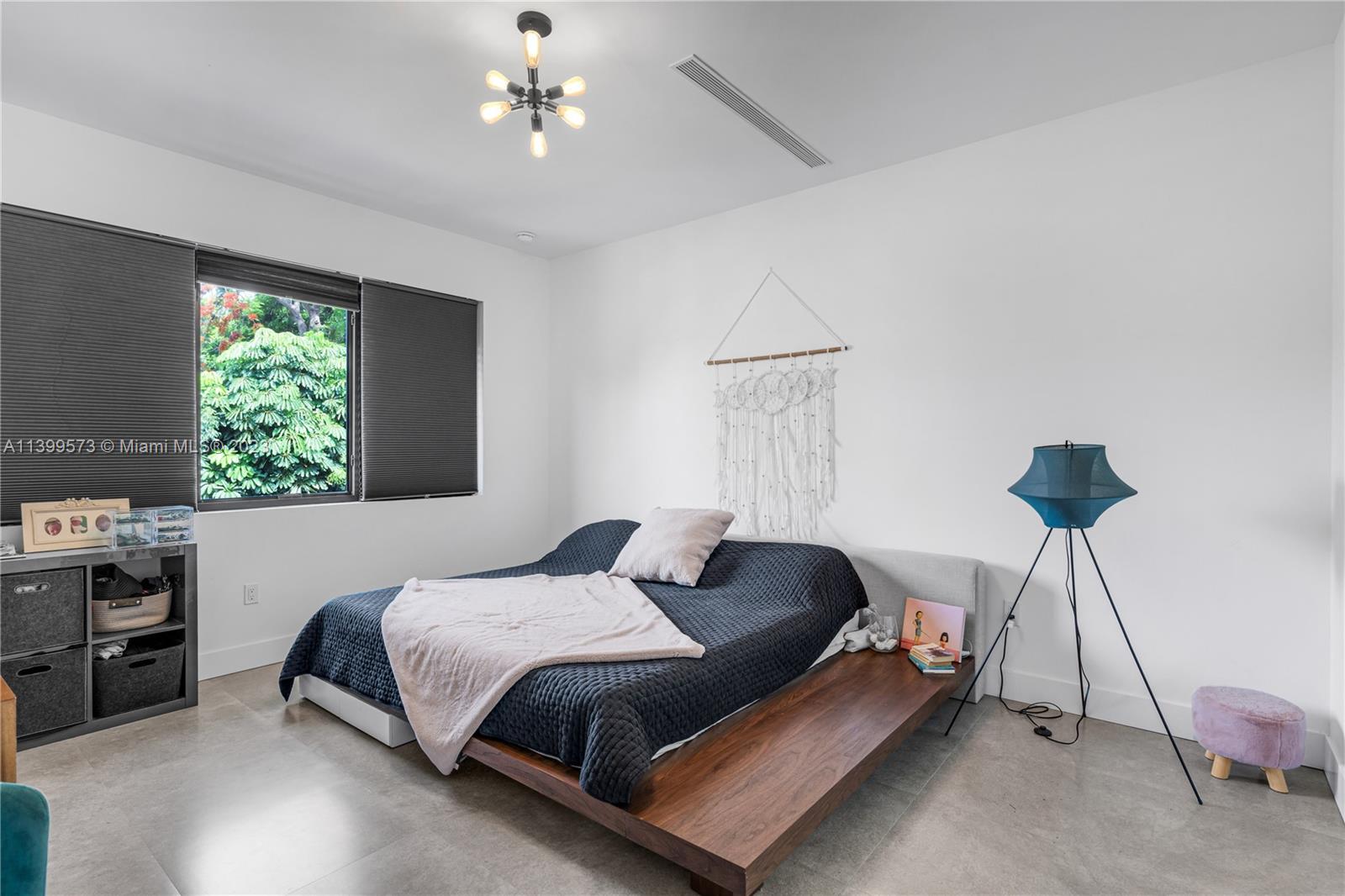 2936 Southwest 35th Avenue, Unit 2936 Miami, FL 33133 - Photo 7 of 22 a bedroom with a bed a chandelier and a window