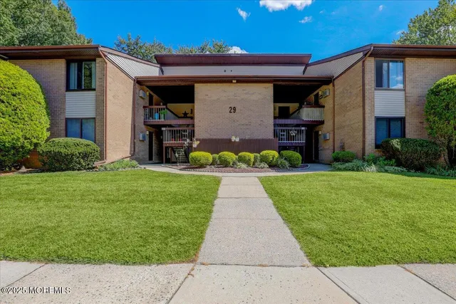 a front view of a house with a yard and potted plants