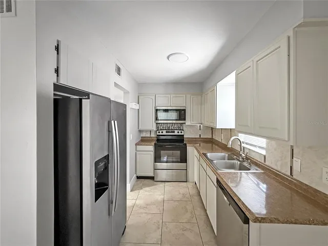 a kitchen with a refrigerator sink and stainless steel appliances