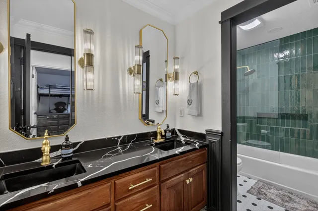 a bathroom with a granite countertop sink a mirror and a bathtub