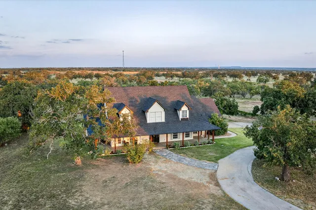 an aerial view of a house with a yard and lake view