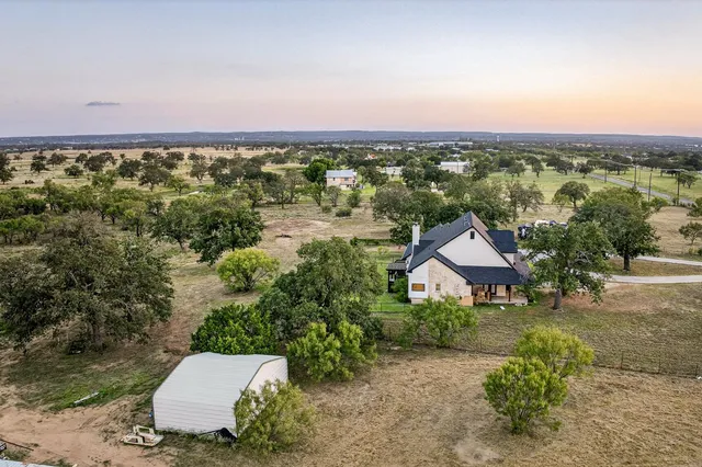 an aerial view of a house with a yard and lake view