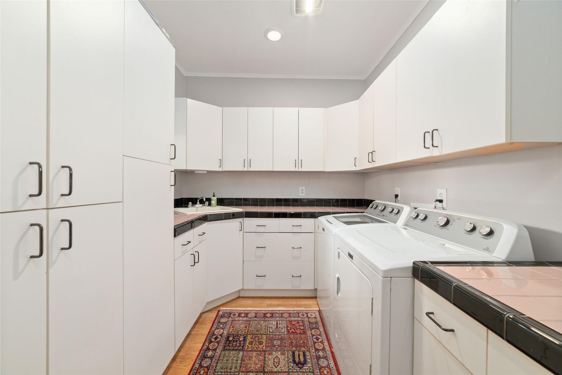 1613 California Street Houston, TX 77006 - Photo 32 of 50 Rarely does a laundry room receive this level of attention. Extensive custom cabinetry, expansive countertops, utility sink, and exceptional storage transform this space into a highly functional extension of the home.