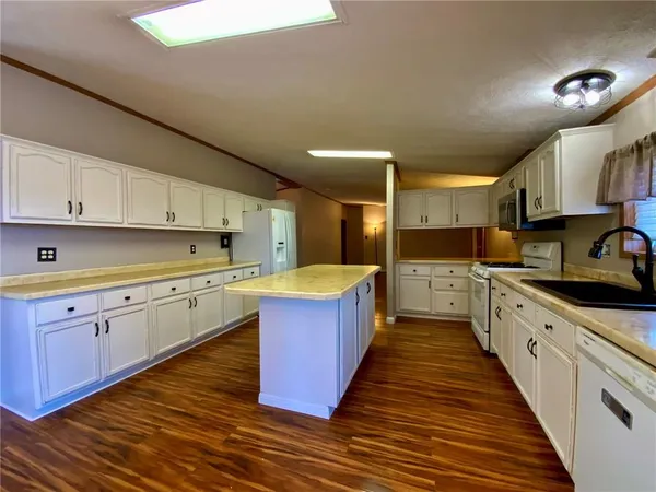 a large kitchen with wooden floors and stainless steel appliances
