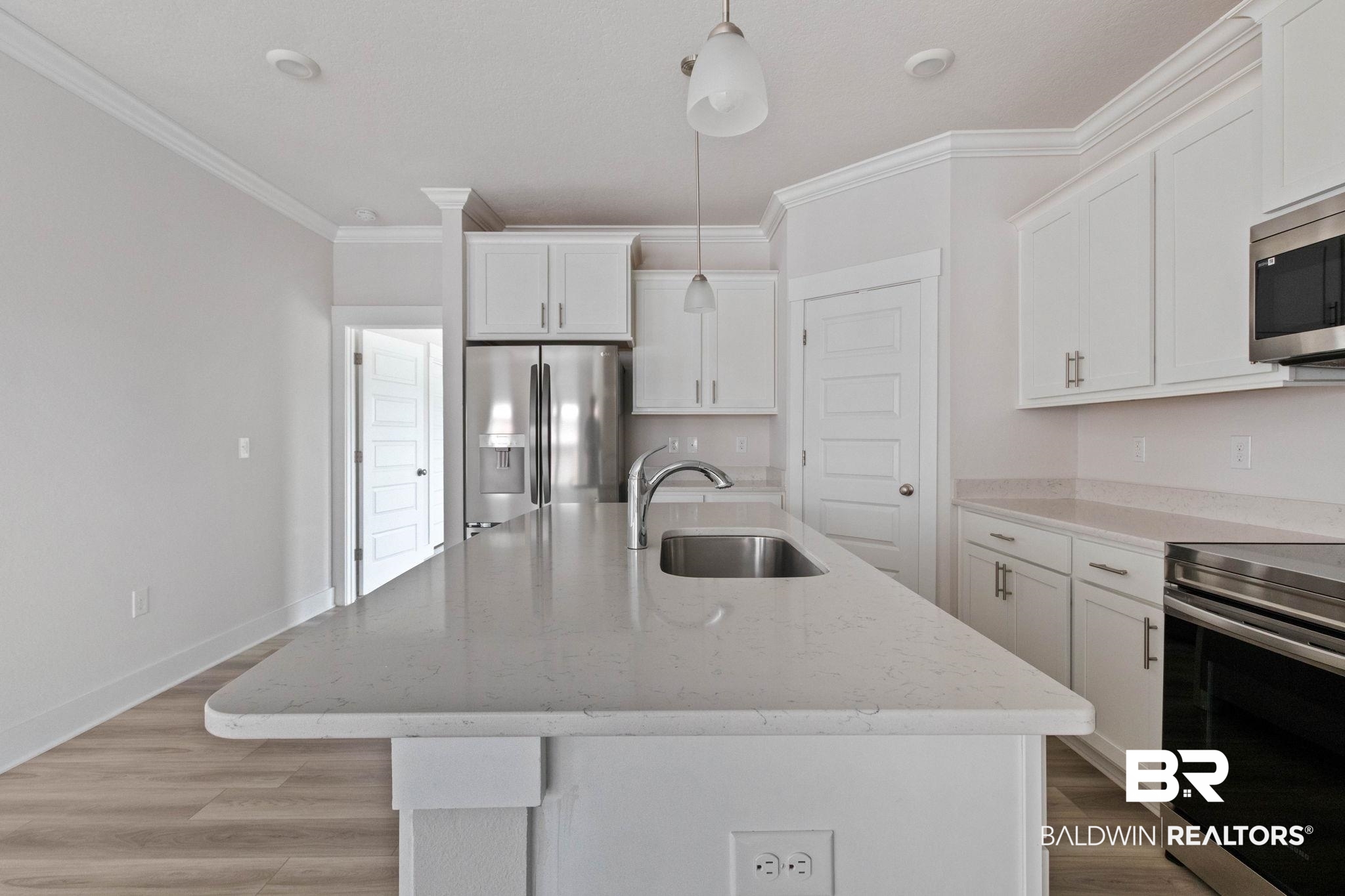 1710 Grouse Street Foley, AL 36535 - Photo 32 of 76 Kitchen island featuring a stainless steel sink and a gooseneck faucet