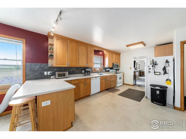 a kitchen with stainless steel appliances kitchen island wooden cabinets a stove a sink a chimney and a refrigerator