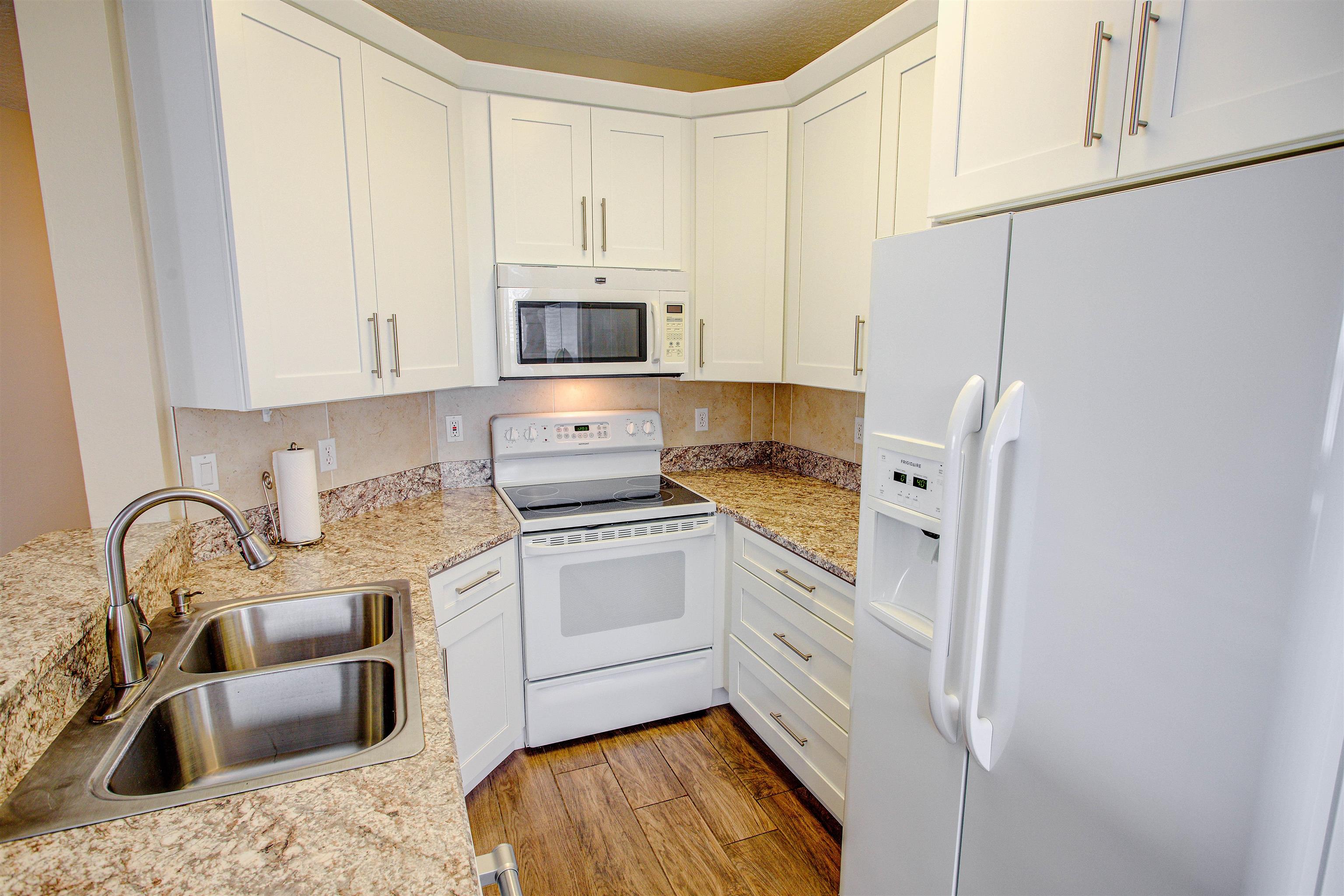 20102 Harbour Vista Circle St. Augustine, FL 32080 - Photo 18 of 31 a kitchen with stainless steel appliances granite countertop a sink a stove a refrigerator with white cabinets and granite countertops