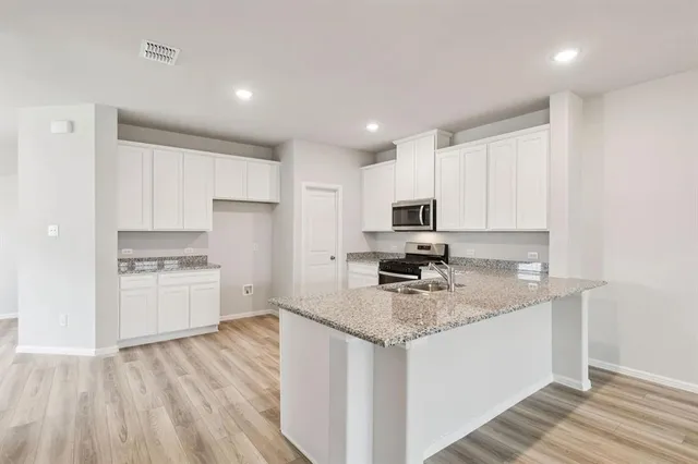 a kitchen with appliances a sink and cabinets