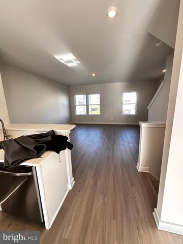 a kitchen with stainless steel appliances a refrigerator and wooden floor