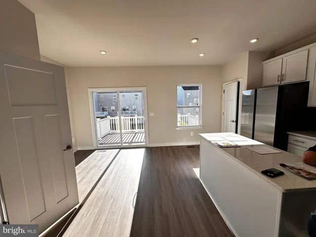 a view of a kitchen with wooden floor and electronic appliances