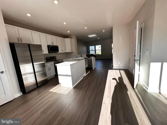 an empty room with wooden floor and window