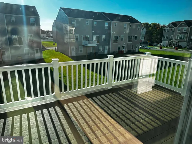 a living room with wooden floors and kitchen view