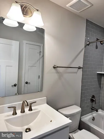 a white toilet sitting next to a bathroom sink