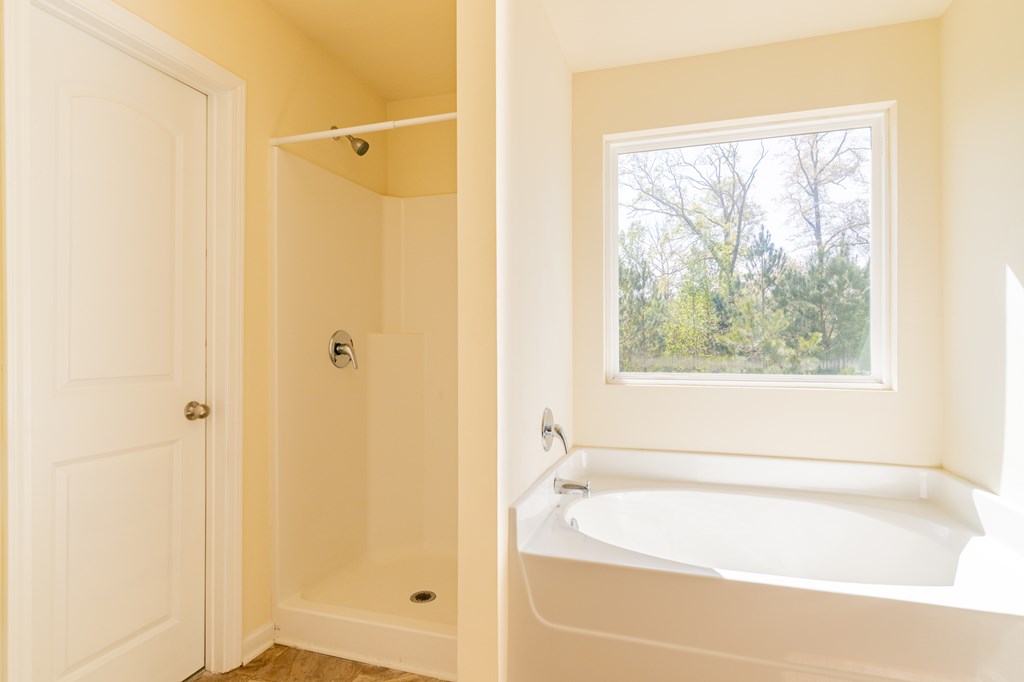 304 Irish Court Phenix City, AL 36869 - Photo 13 of 20 a bathroom with a tub a shower and a window
