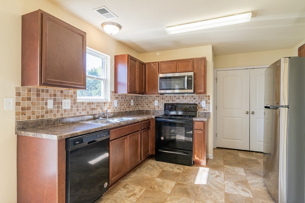 304 Irish Court Phenix City, AL 36869 - Photo 6 of 20 a kitchen with stainless steel appliances granite countertop a stove a sink dishwasher a refrigerator and a microwave oven