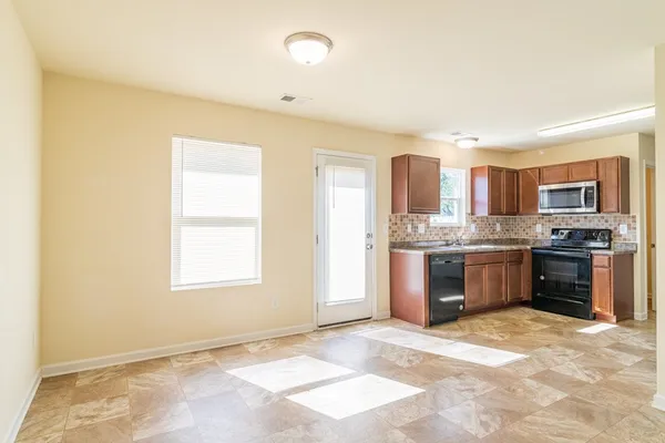 a kitchen with stainless steel appliances granite countertop a stove top oven a sink and dishwasher