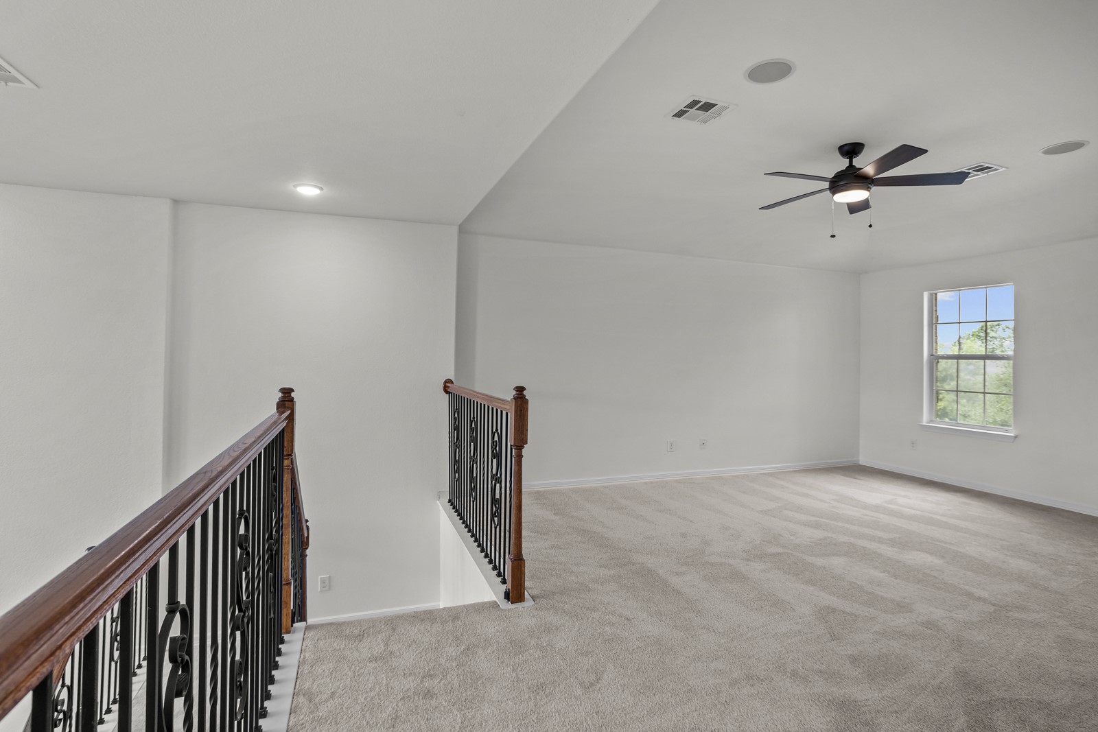245 Razzmatazz Trail Buda, TX 78610 - Photo 23 of 37 Spacious second-level room with light-toned carpeting and a window offering natural illumination