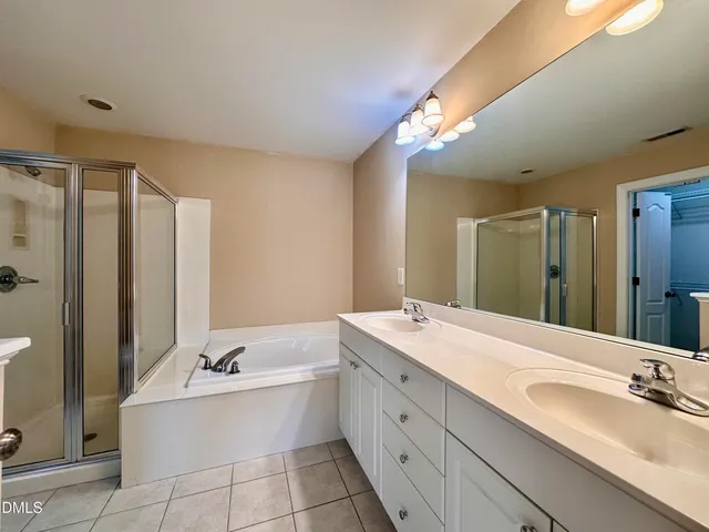a bathroom with a tub a double vanity sink and mirror