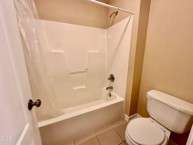 a white toilet and tub sitting next to a bathroom sink
