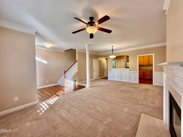 a view of a livingroom with a ceiling fan and kitchen view